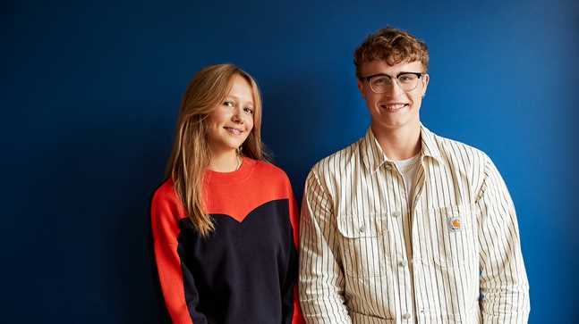 Portræt af 2 HHX elever fra Niels Brock med blå baggrund