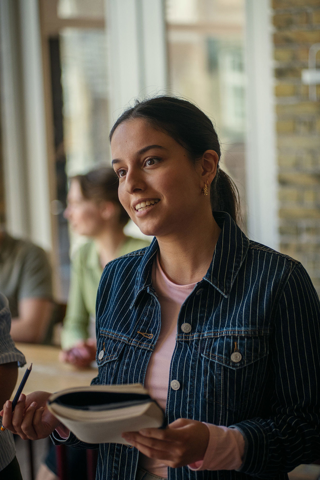 Elev fra Det Internationale Gymnasium står med en bog
