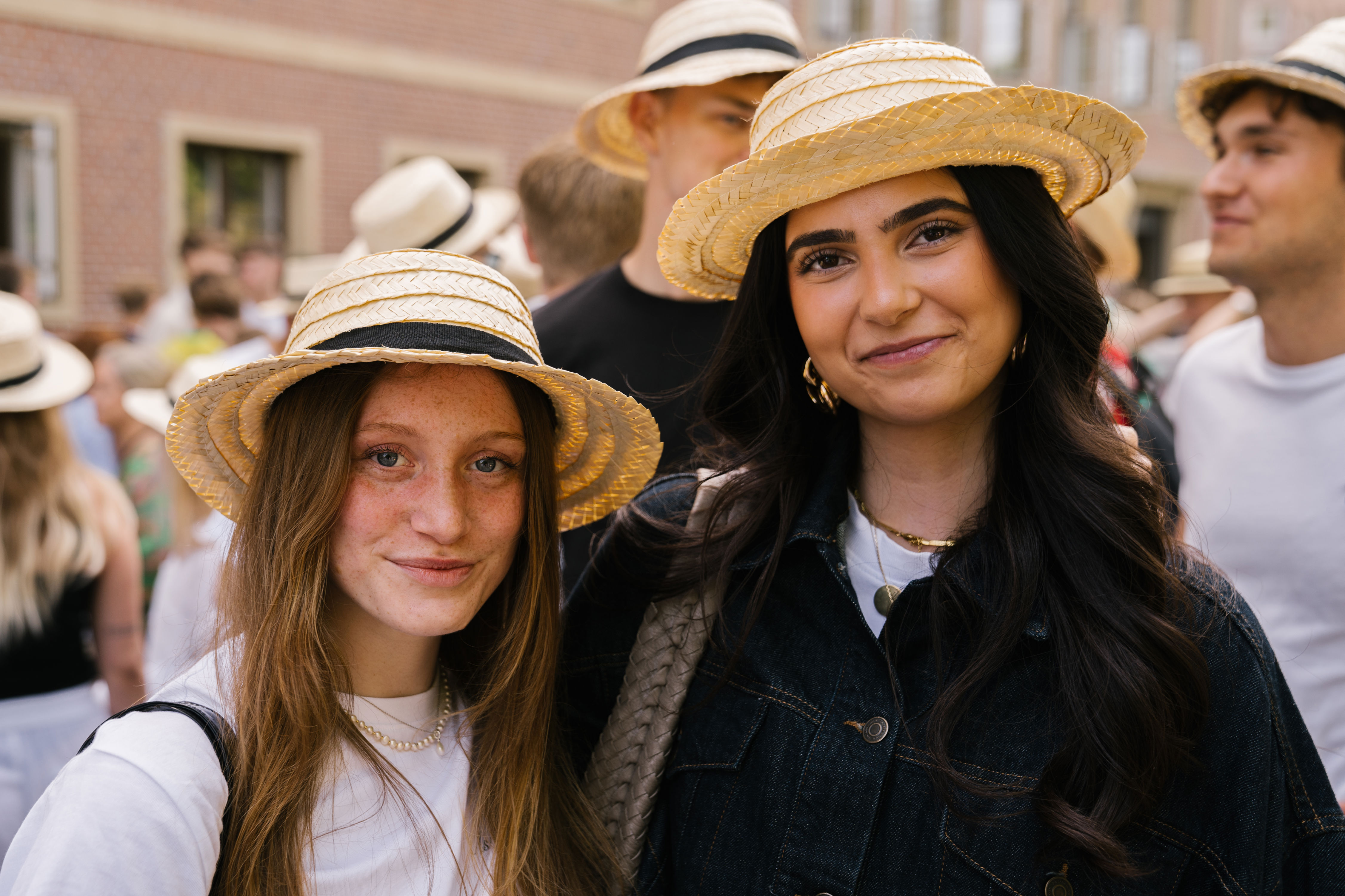 To elever står med stråhatte på til stråhattedag