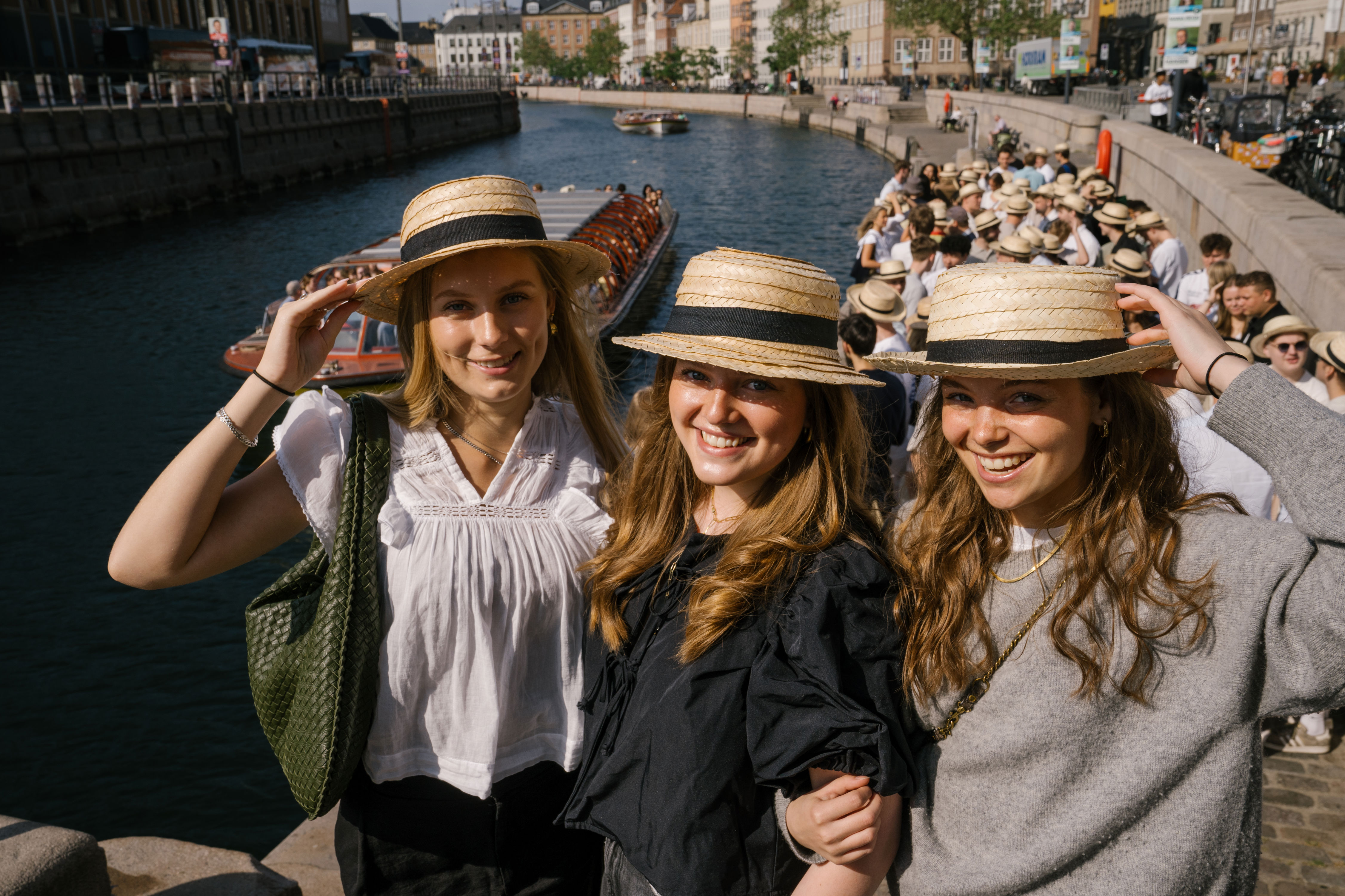 Tre elever står med stråhatte på til stråhattedag