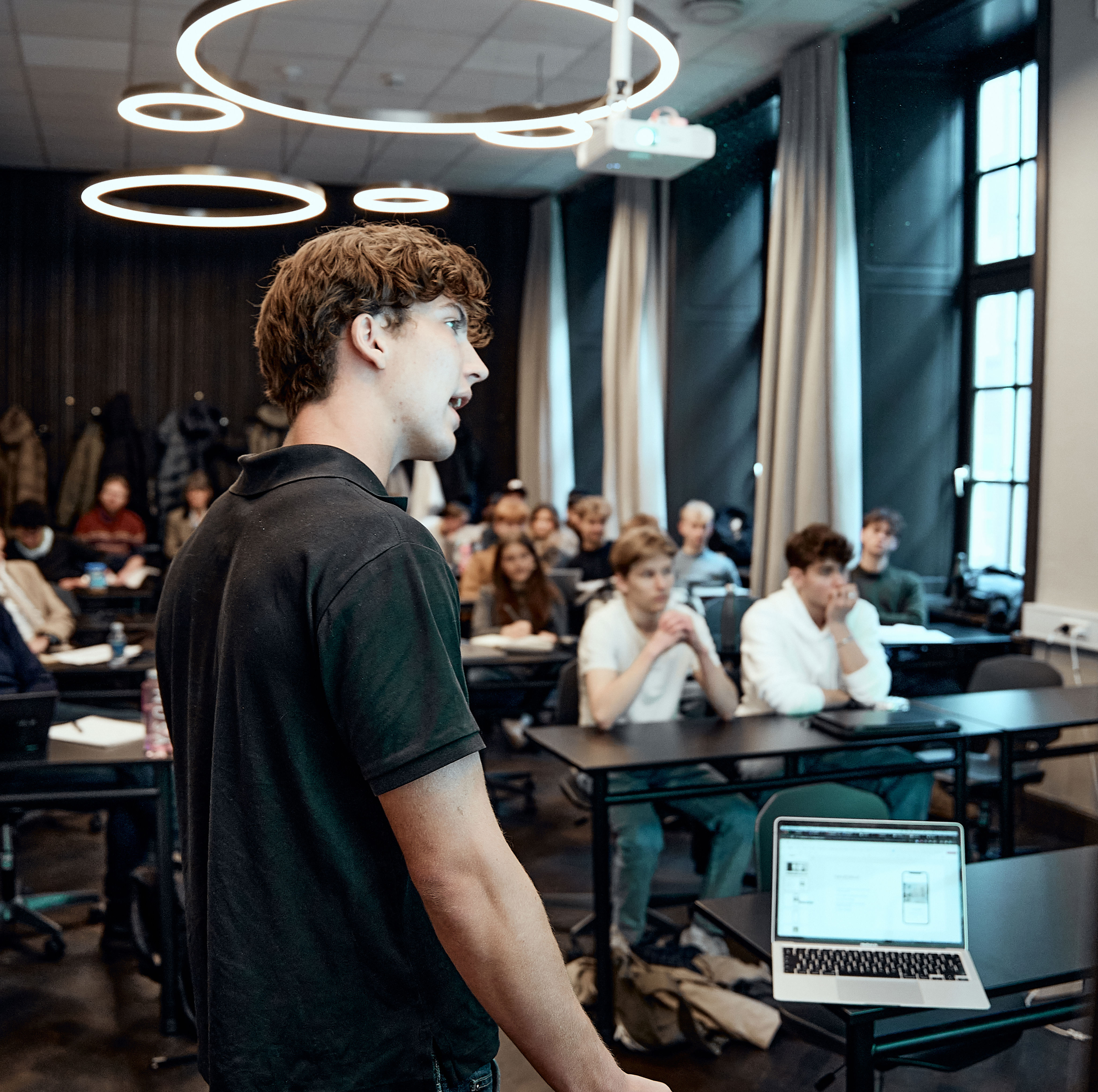 Elev fra Jesper Buchs Iværksætterakademi står og præsenter noget foran en klasse