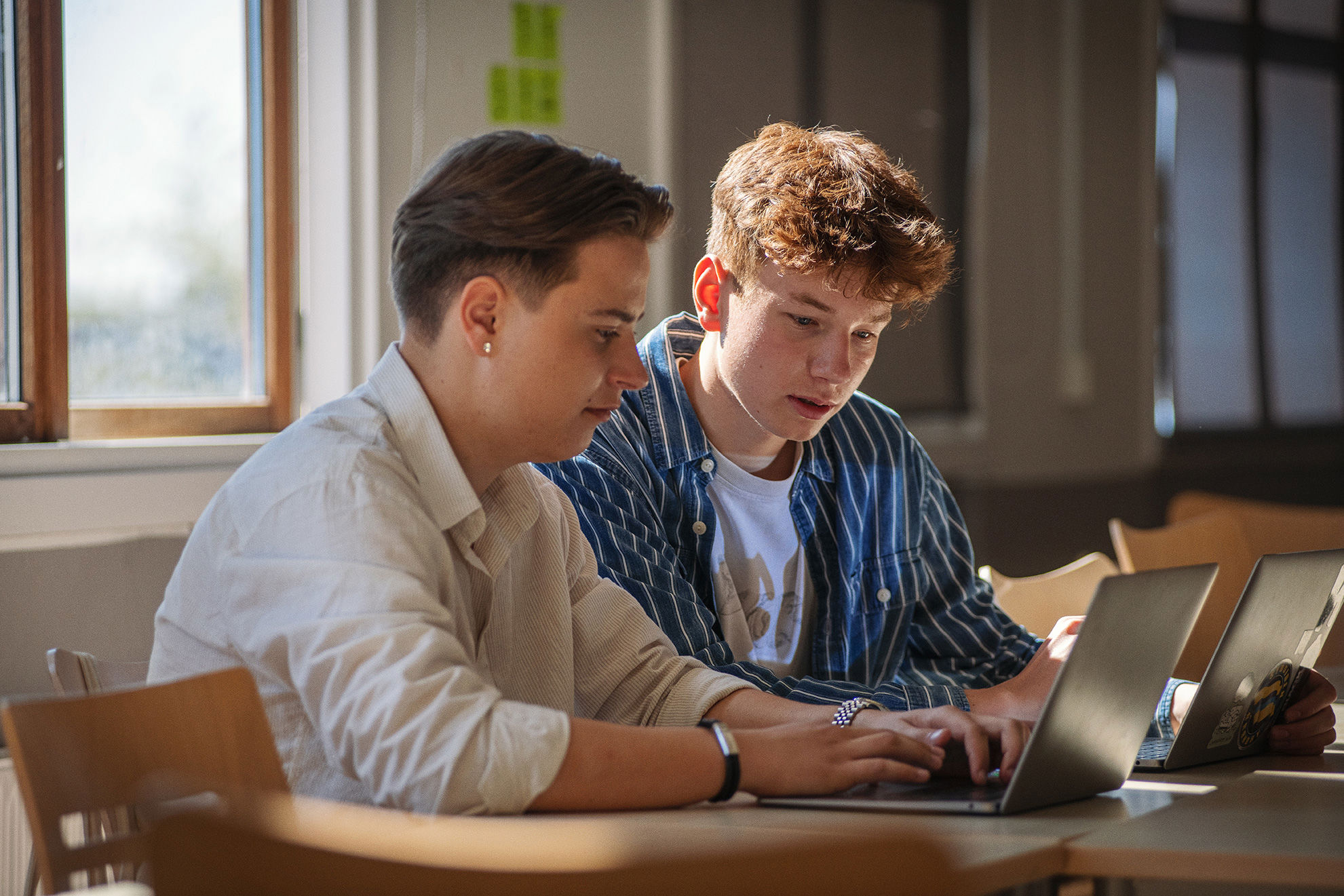 Elever fra Innovationsgymnasiet sider og arbejder på en computer